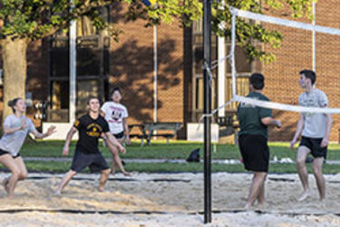 photo of students playing volleyball on campus
