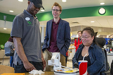 photo of a student with a staff member and obi