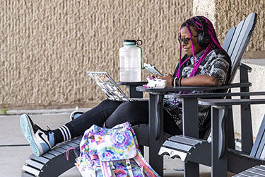 photo of a student sitting outside on campus