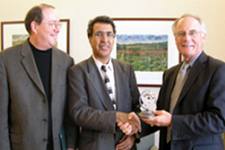 Fall Ainina, Professor and Chair of the Department of Finance and Financial Services with Provost David Hopkins, right, and Doug