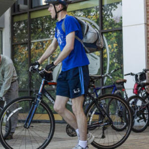 photo of an employee and bicycle on campus