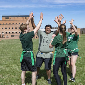 photo of students high-fiving on the football field